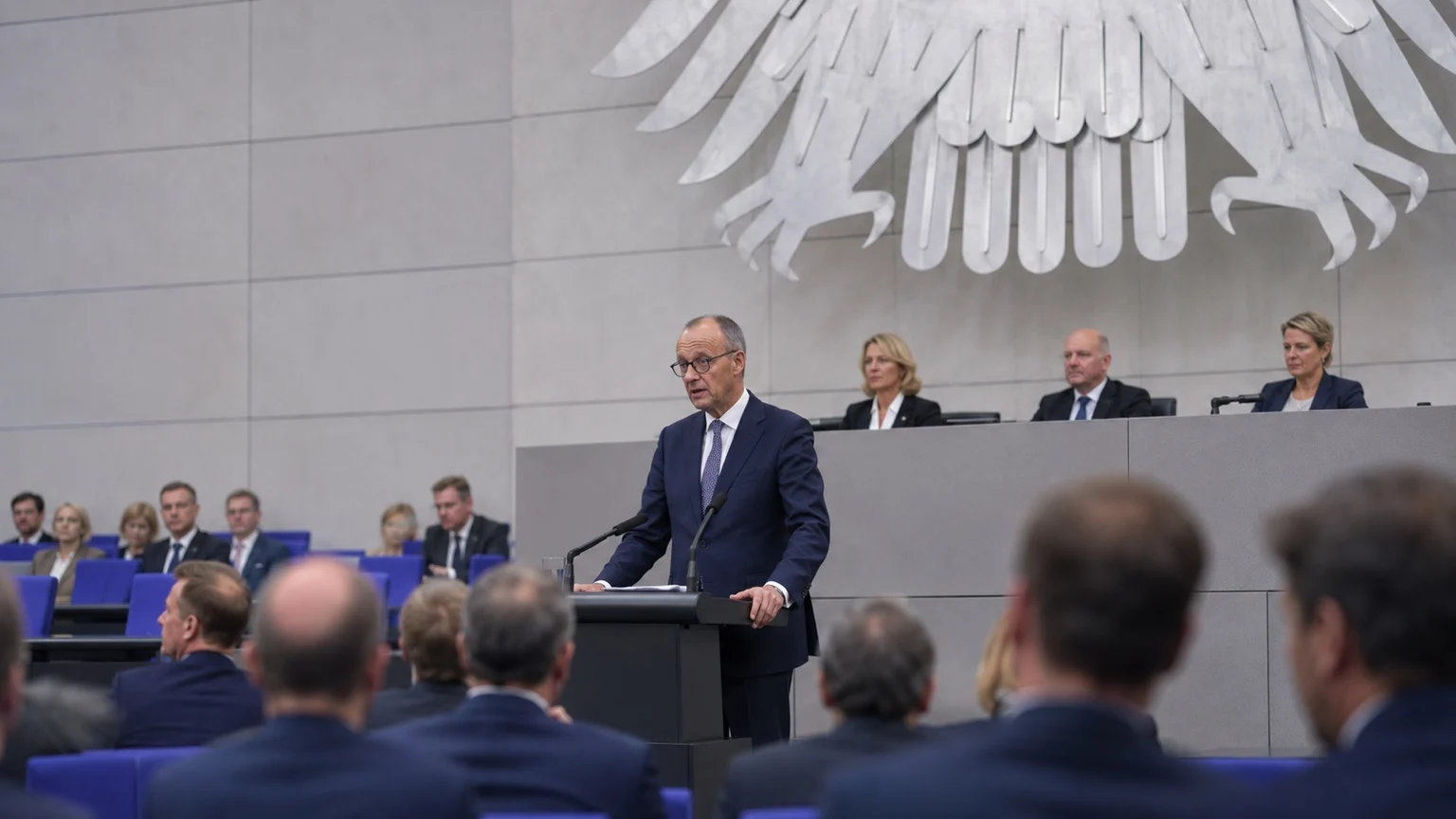 KI-generierte Illustration: Kanzler Friedrich Merz am Rednerpult im Plenarsaal des Bundestags